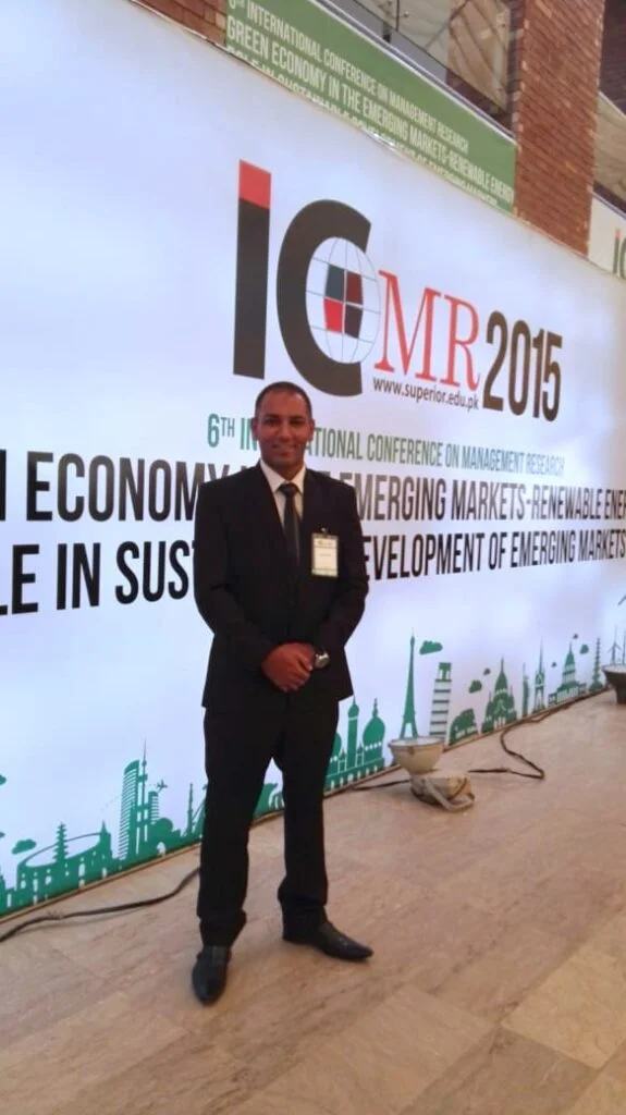 Muhammad Azam, SEO expert for local businesses, standing at ICMR 2015 conference backdrop.