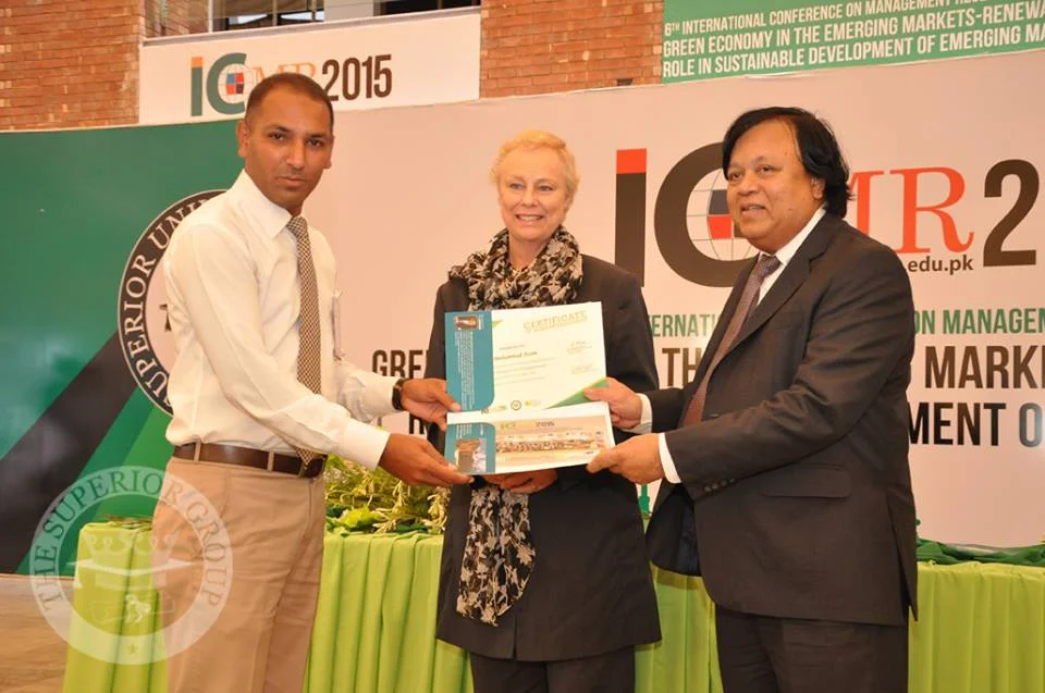 Muhammad Azam, SEO expert for local businesses, receives a certificate from international professors after a marketing research presentation.
